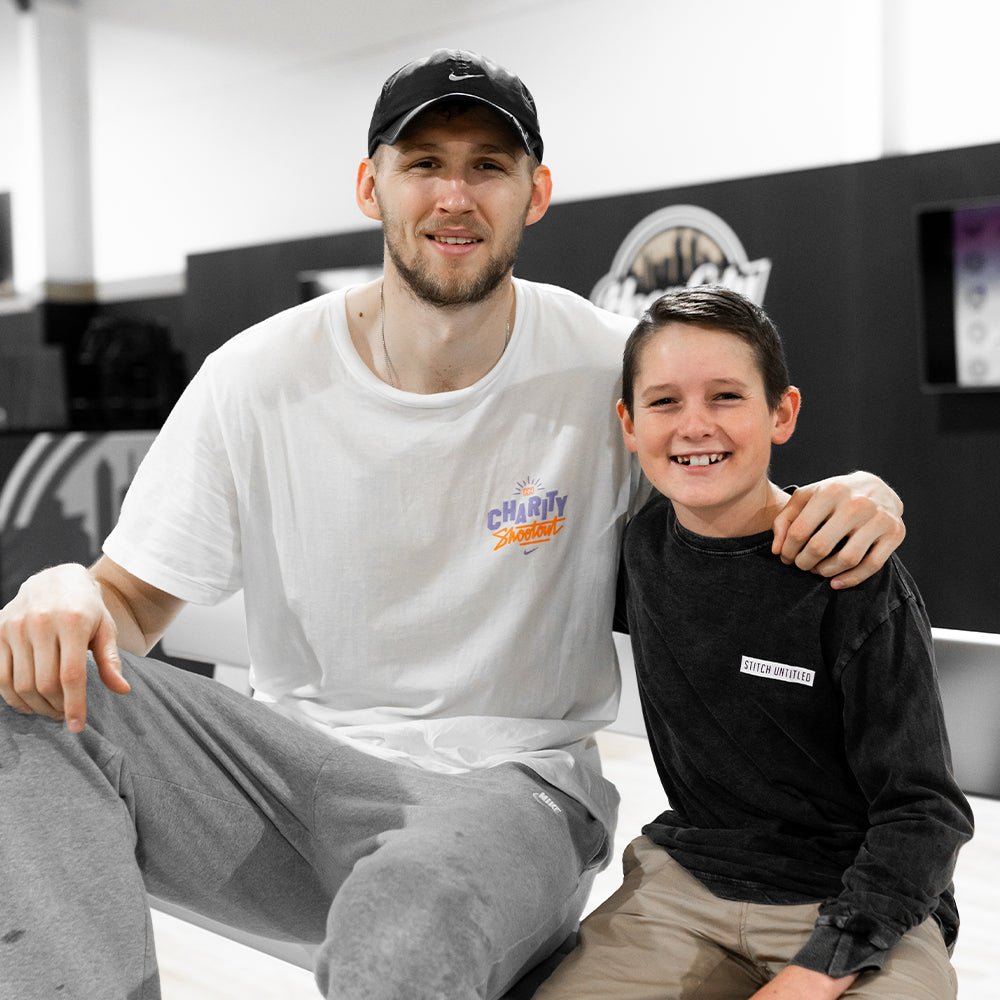 Max Becker wearing stitch untitled sitting on bench with NBA star Jock Landale