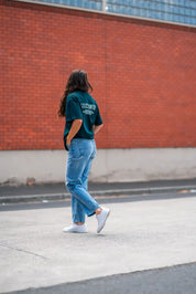 Person crossing Melbourne street wearing green stitch untitled club tee