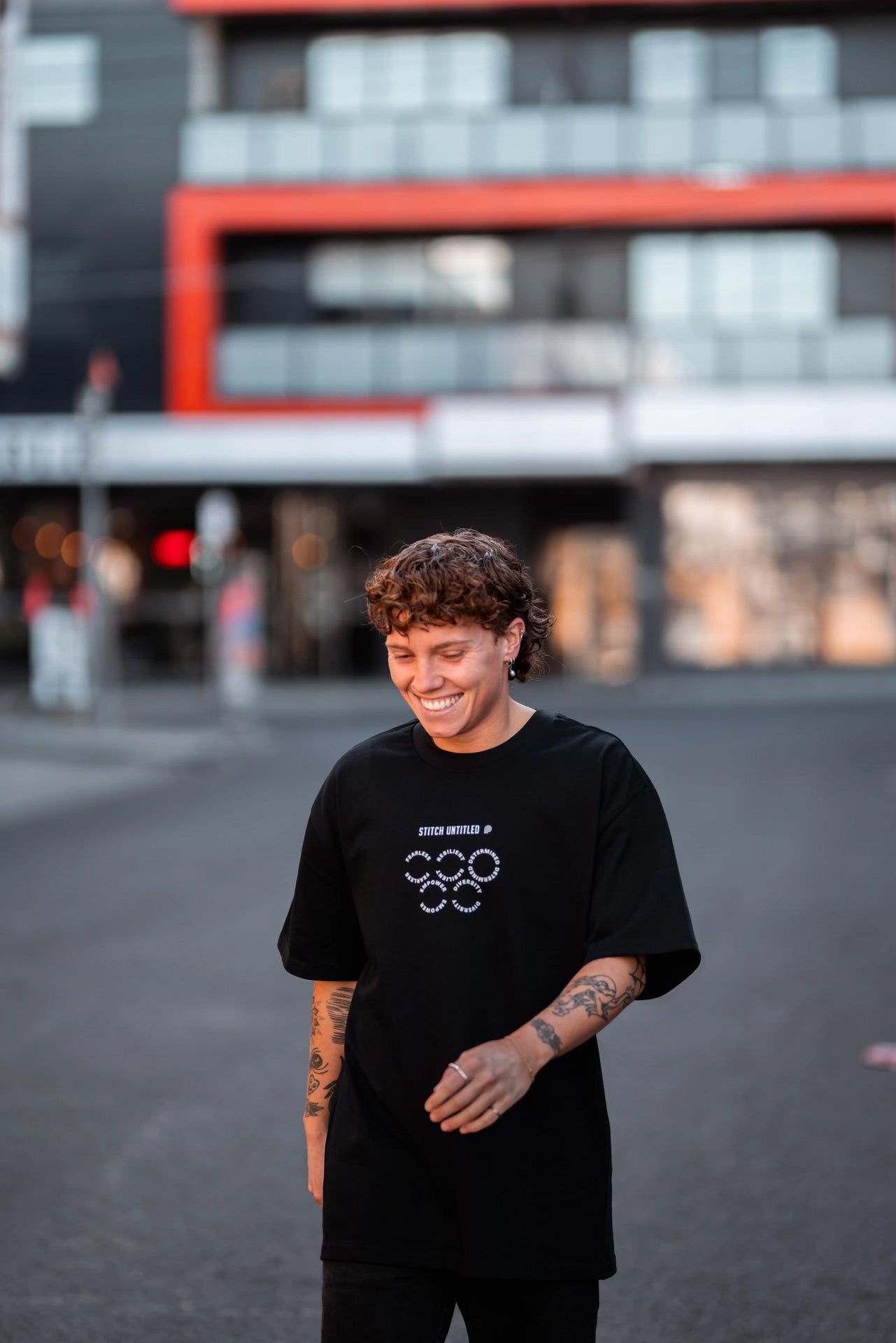 Tilly Lucas-Rodd walking down Melbourne city street wearing a Pride Cup and Stitch Untitled collaboration tee