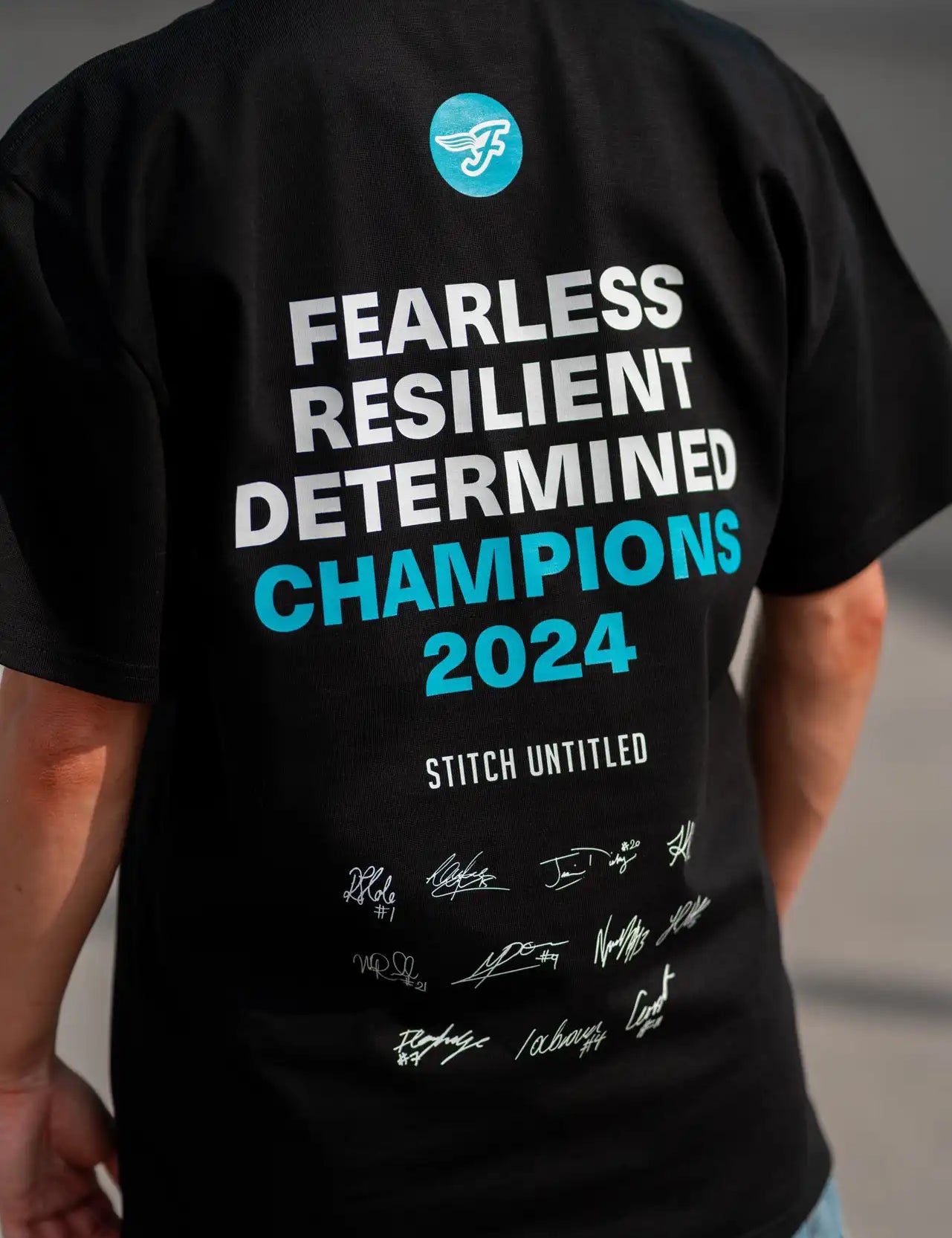 Person wearing a Stitch Untitled and Southside Flyers collaborative Champions Tee